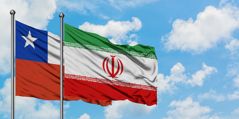Chile and Iran flag waving in the wind against white cloudy blue sky together. Diplomacy concept, international relations.