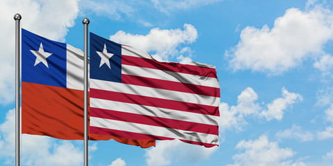 Chile and Liberia flag waving in the wind against white cloudy blue sky together. Diplomacy concept, international relations.