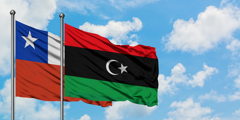 Chile and Libya flag waving in the wind against white cloudy blue sky together. Diplomacy concept, international relations.