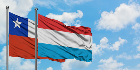 Chile and Luxembourg flag waving in the wind against white cloudy blue sky together. Diplomacy concept, international relations.