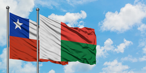 Chile and Madagascar flag waving in the wind against white cloudy blue sky together. Diplomacy concept, international relations.