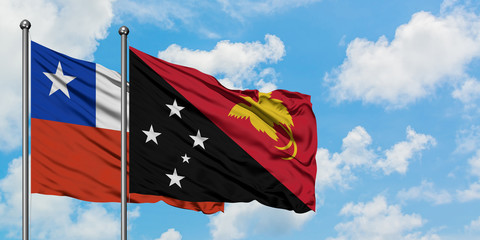 Chile and Papua New Guinea flag waving in the wind against white cloudy blue sky together. Diplomacy concept, international relations.