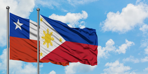 Chile and Philippines flag waving in the wind against white cloudy blue sky together. Diplomacy concept, international relations.