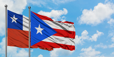 Chile and Puerto Rico flag waving in the wind against white cloudy blue sky together. Diplomacy concept, international relations.