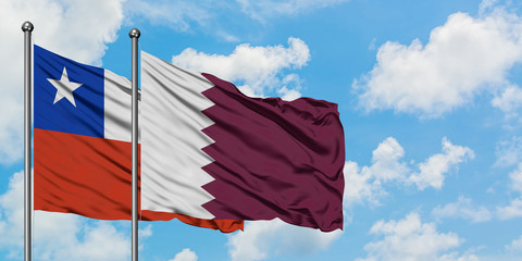 Chile and Qatar flag waving in the wind against white cloudy blue sky together. Diplomacy concept, international relations.