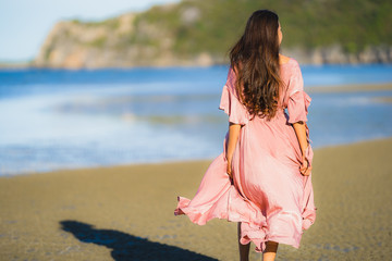 Portrait young beautiful asian woman walk smile and happy on the beach sea and ocean