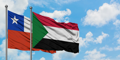 Chile and Sudan flag waving in the wind against white cloudy blue sky together. Diplomacy concept, international relations.