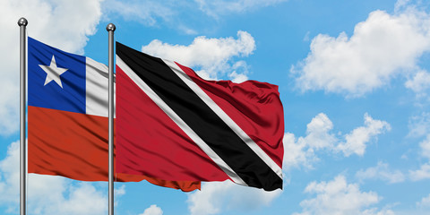 Chile and Trinidad And Tobago flag waving in the wind against white cloudy blue sky together. Diplomacy concept, international relations.