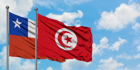 Chile and Tunisia flag waving in the wind against white cloudy blue sky together. Diplomacy concept, international relations.