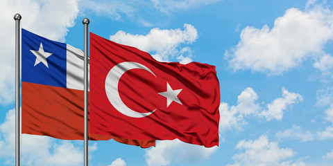 Chile and Turkey flag waving in the wind against white cloudy blue sky together. Diplomacy concept, international relations.