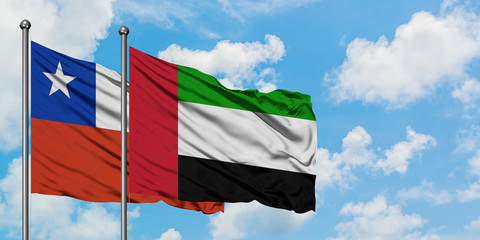 Chile and United Arab Emirates flag waving in the wind against white cloudy blue sky together. Diplomacy concept, international relations.