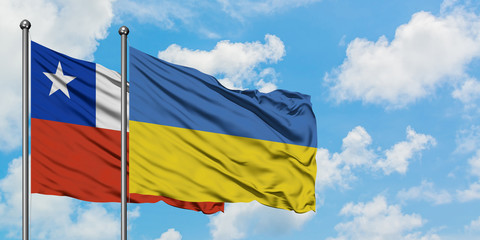 Chile and Ukraine flag waving in the wind against white cloudy blue sky together. Diplomacy concept, international relations.