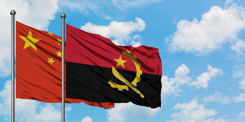 China and Angola flag waving in the wind against white cloudy blue sky together. Diplomacy concept, international relations.