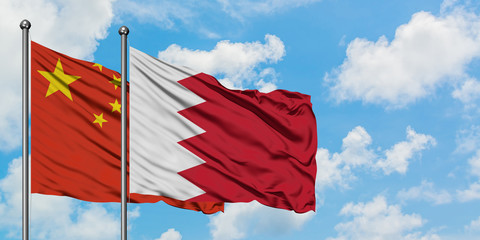 China and Bahrain flag waving in the wind against white cloudy blue sky together. Diplomacy concept, international relations.