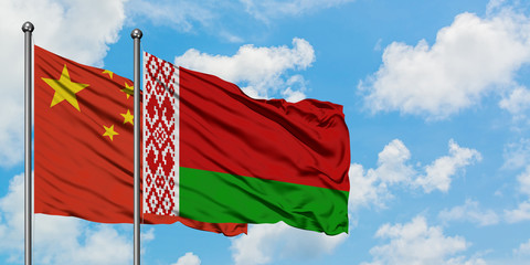 China and Belarus flag waving in the wind against white cloudy blue sky together. Diplomacy concept, international relations.
