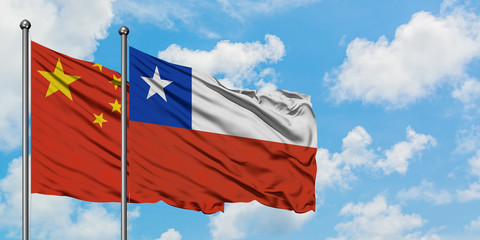 China and Chile flag waving in the wind against white cloudy blue sky together. Diplomacy concept, international relations.