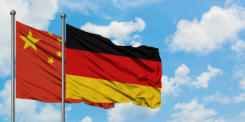 China and Germany flag waving in the wind against white cloudy blue sky together. Diplomacy concept, international relations.