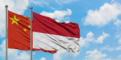 China and Monaco flag waving in the wind against white cloudy blue sky together. Diplomacy concept, international relations.