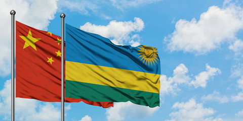 China and Rwanda flag waving in the wind against white cloudy blue sky together. Diplomacy concept, international relations.