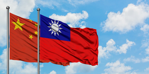 China and Taiwan flag waving in the wind against white cloudy blue sky together. Diplomacy concept, international relations.