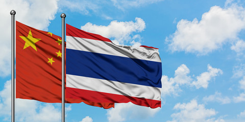 China and Thailand flag waving in the wind against white cloudy blue sky together. Diplomacy concept, international relations.