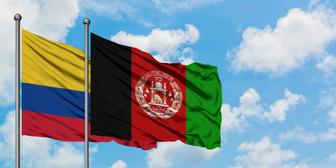 Colombia and Afghanistan flag waving in the wind against white cloudy blue sky together. Diplomacy concept, international relations.