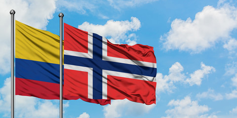 Colombia and Bouvet Islands flag waving in the wind against white cloudy blue sky together. Diplomacy concept, international relations.