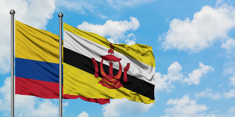 Colombia and Brunei flag waving in the wind against white cloudy blue sky together. Diplomacy concept, international relations.