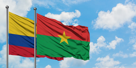 Colombia and Burkina Faso flag waving in the wind against white cloudy blue sky together. Diplomacy concept, international relations.