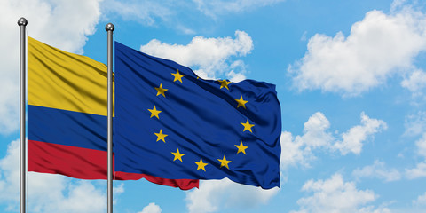 Colombia and European Union flag waving in the wind against white cloudy blue sky together. Diplomacy concept, international relations.