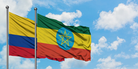 Colombia and Ethiopia flag waving in the wind against white cloudy blue sky together. Diplomacy concept, international relations.