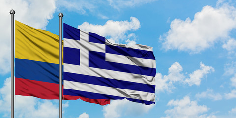 Colombia and Greece flag waving in the wind against white cloudy blue sky together. Diplomacy concept, international relations.