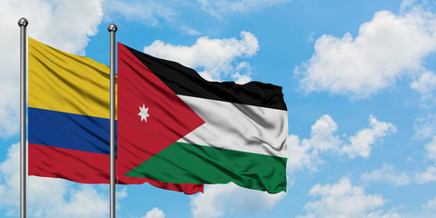 Colombia and Jordan flag waving in the wind against white cloudy blue sky together. Diplomacy concept, international relations.