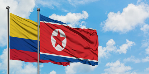 Colombia and North Korea flag waving in the wind against white cloudy blue sky together. Diplomacy concept, international relations.