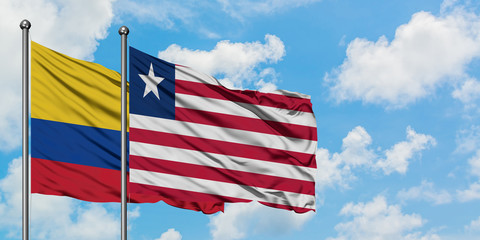 Colombia and Liberia flag waving in the wind against white cloudy blue sky together. Diplomacy concept, international relations.
