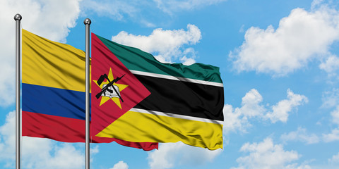 Colombia and Mozambique flag waving in the wind against white cloudy blue sky together. Diplomacy concept, international relations.