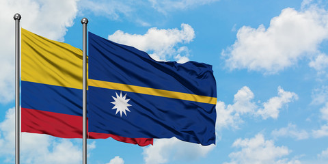 Colombia and Nauru flag waving in the wind against white cloudy blue sky together. Diplomacy concept, international relations.