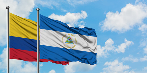 Colombia and Nicaragua flag waving in the wind against white cloudy blue sky together. Diplomacy concept, international relations.