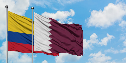 Colombia and Qatar flag waving in the wind against white cloudy blue sky together. Diplomacy concept, international relations.
