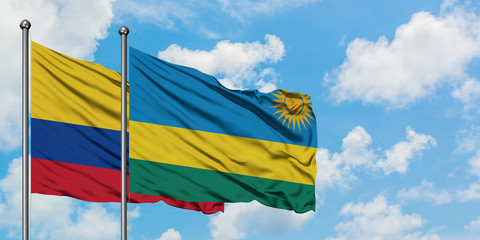 Colombia and Rwanda flag waving in the wind against white cloudy blue sky together. Diplomacy concept, international relations.