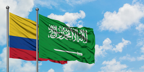 Colombia and Saudi Arabia flag waving in the wind against white cloudy blue sky together. Diplomacy concept, international relations.