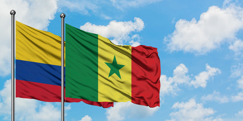 Colombia and Senegal flag waving in the wind against white cloudy blue sky together. Diplomacy concept, international relations.