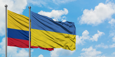 Colombia and Ukraine flag waving in the wind against white cloudy blue sky together. Diplomacy concept, international relations.