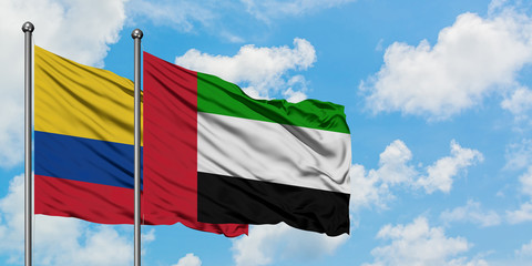 Colombia and United Arab Emirates flag waving in the wind against white cloudy blue sky together. Diplomacy concept, international relations.