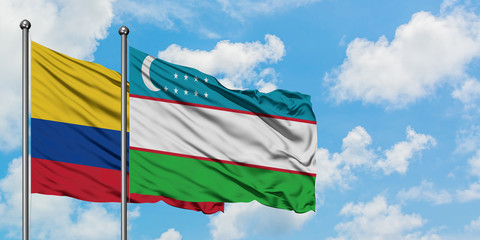 Colombia and Uzbekistan flag waving in the wind against white cloudy blue sky together. Diplomacy concept, international relations.
