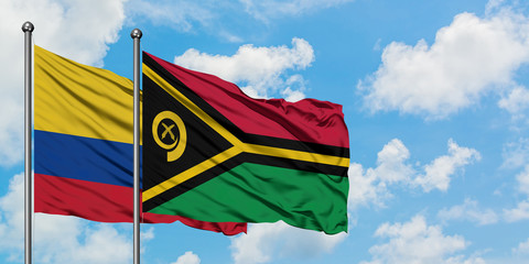 Colombia and Vanuatu flag waving in the wind against white cloudy blue sky together. Diplomacy concept, international relations.