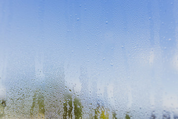 humidity droplets on window with bokeh of mountain landscape