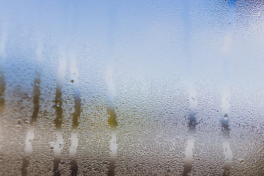 humidity droplets on window with bokeh of mountain landscape