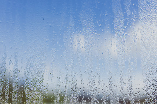 humidity droplets on window with bokeh of mountain landscape