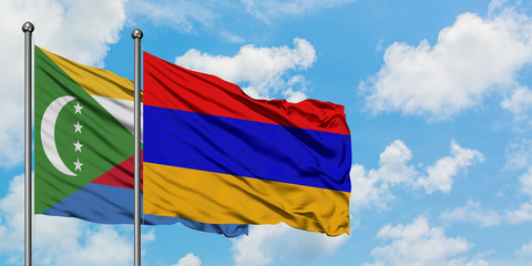 Comoros and Armenia flag waving in the wind against white cloudy blue sky together. Diplomacy concept, international relations.